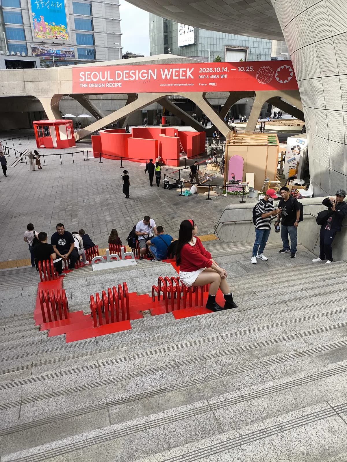 Una instalación roja y gente en las escaleras frente al DDP