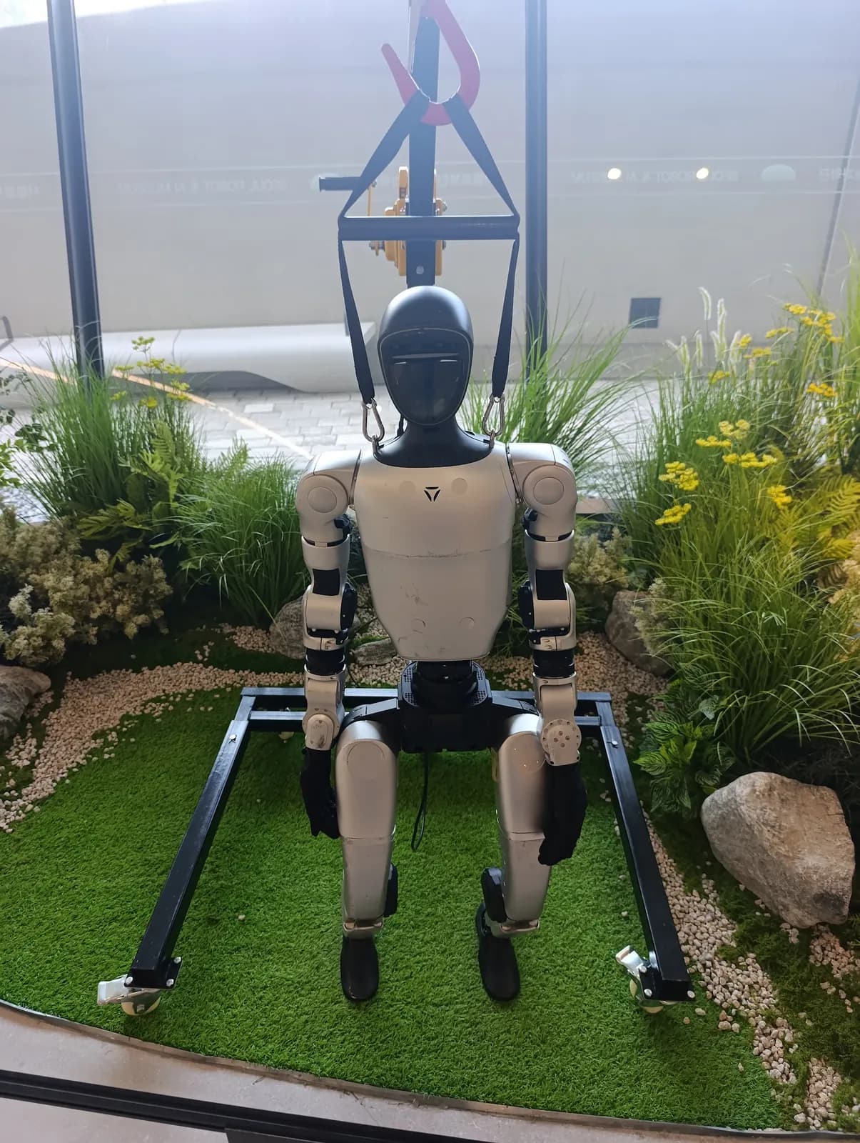 Un robot humanoide expuesto entre plantas en el museo