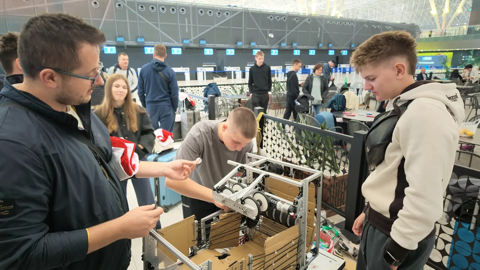 Članovi hrvatske ekipe pregledavaju robota i transportnu kutiju na aerodromu