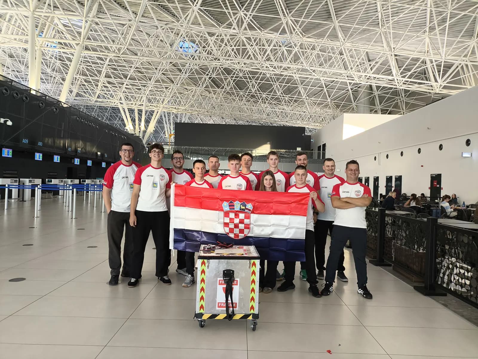 Hrvatska ekipa s nacionalnom zastavom i kutijom za robota na zagrebačkom aerodromu