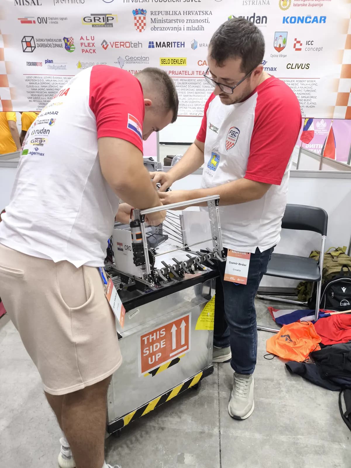 Dva člana hrvatskog tima podešavaju robota u pitu
