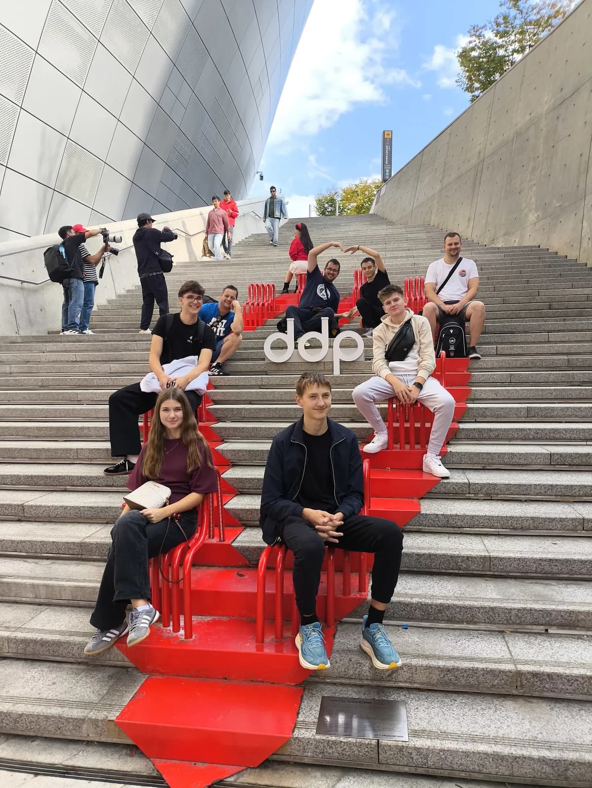 Miembros del equipo sentados en las escaleras frente al DDP